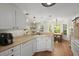 Well-lit kitchen featuring white cabinets, countertops, and view of dining area at 1087 Clearspring Dr, Charleston, SC 29412