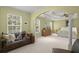 Bright main bedroom with tray ceilings, a seating area, and large windows at 1087 Clearspring Dr, Charleston, SC 29412