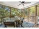 Cozy screened porch with a dining table, chairs, ceiling fan, and scenic views of the surrounding greenery at 1087 Clearspring Dr, Charleston, SC 29412