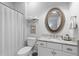 Well-lit bathroom featuring a granite vanity top and a decorative oval mirror at 112 Berkshire Dr, Wando, SC 29492