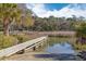 Waterfront view of a dock with a beach and marshy water at 112 Berkshire Dr, Wando, SC 29492