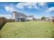 Home's backyard includes a full fence, green grass, and screened-in porch at 1130 Moss Grove Dr, Moncks Corner, SC 29461