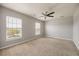 Well-lit bedroom featuring carpet flooring, ceiling fan, and two large windows at 1130 Moss Grove Dr, Moncks Corner, SC 29461