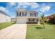 Charming two-story home with a well-manicured lawn, attached garage, and inviting front porch, perfect for suburban living at 1130 Moss Grove Dr, Moncks Corner, SC 29461