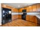 Well-lit kitchen with black appliances and wooden cabinets, complemented by wood-look flooring at 1130 Moss Grove Dr, Moncks Corner, SC 29461