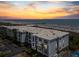 Coastal condo aerial view showcases beachfront access, balcony views, and vibrant sunset skies on a well-populated beach at 1140 Ocean Blvd # 201, Isle of Palms, SC 29451