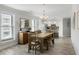 Bright dining area featuring wood table with bench, chandelier and adjacent kitchen, creating an inviting space at 1140 Ocean Blvd # 201, Isle of Palms, SC 29451