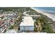 Aerial view of a multi-story building near a beach, with a pool, a parking lot, and lush landscaping at 1140 Ocean Blvd # 201, Isle of Palms, SC 29451