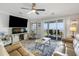 Inviting living room boasts stylish furnishings, large screen TV, ceiling fan, and sliding glass door to a balcony with ocean views at 1140 Ocean Blvd # 201, Isle of Palms, SC 29451
