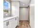 Hallway with cabinets and wood-look floors, enhanced by natural light from the window, creating an inviting atmosphere at 119 Silver King Ave, Cross, SC 29436