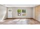 An empty living room with natural light streaming through windows and a door, highlighting the wood-look flooring at 119 Silver King Ave, Cross, SC 29436