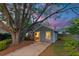 Twilight view of a gray home with a well-lit front porch and lush landscaping at 1224 Decoy Ct, Mount Pleasant, SC 29464