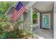 Charming covered front porch featuring an American flag, house number, and a hanging fern at 1224 Decoy Ct, Mount Pleasant, SC 29464