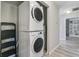 Laundry area featuring a stacked washer and dryer set, wood-look flooring, and access to additional shelving at 1224 Decoy Ct, Mount Pleasant, SC 29464