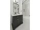 Modern bathroom features a dark vanity with a marble countertop, white subway tile shower, and herringbone floors at 1228 Penny Cir, Mount Pleasant, SC 29464