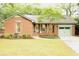 Charming brick home with a well-manicured lawn, complemented by a lovely tree and matching garage and door accents at 1228 Penny Cir, Mount Pleasant, SC 29464