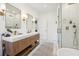 Bright bathroom featuring a double sink vanity with wood cabinets and a walk-in shower at 1483 Harborsun Dr, Charleston, SC 29412