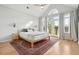 Sunlit bedroom features a vaulted ceiling, French doors, a decorative rug, and light wood flooring at 1483 Harborsun Dr, Charleston, SC 29412