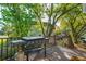 Wooden deck with a gas grill overlooking mature trees and the rooflines of nearby houses at 1483 Harborsun Dr, Charleston, SC 29412
