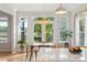 Dining room with a modern chandelier and a view to the outdoor deck and mature landscaping at 1483 Harborsun Dr, Charleston, SC 29412