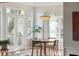 Dining room features a round wooden table, four chairs, large windows, and a decorative light fixture at 1483 Harborsun Dr, Charleston, SC 29412