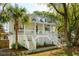 Beautiful two-story home featuring a welcoming front porch and mature palm trees at 1483 Harborsun Dr, Charleston, SC 29412