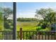 Scenic view of marsh and trees through a sliding glass door and deck railing at 1483 Harborsun Dr, Charleston, SC 29412