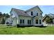 The backyard features green grass, a white picket fence, and mature trees at 15 Muirfield Village Ct, Summerville, SC 29483