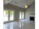 Open living room with tile flooring, high ceilings, fireplace, and access to the outdoor space through glass doors at 15 Muirfield Village Ct, Summerville, SC 29483