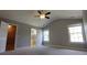 Spacious main bedroom features plush carpet, ample natural light, a ceiling fan, and ensuite bathroom access at 15 Muirfield Village Ct, Summerville, SC 29483