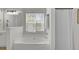 Bright bathroom featuring a soaking tub under a window and striped shower curtain for a spa-like retreat at 1634 Pin Oak Cut, Mount Pleasant, SC 29466