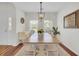 Well-lit dining room with a large wooden table, white chairs, and natural light from large windows at 1634 Pin Oak Cut, Mount Pleasant, SC 29466