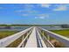A private dock with a white wooden walkway stretches out onto the water on a sunny day at 1634 Pin Oak Cut, Mount Pleasant, SC 29466