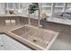 Modern kitchen sink with stainless steel fixtures, light cabinetry, and a view to the outside living space at 1634 Pin Oak Cut, Mount Pleasant, SC 29466