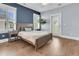 Well-lit bedroom with natural wood floors, a blue accent wall, and an outdoor entrance at 1658 Pierce St, Charleston, SC 29492