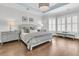 Bright bedroom features hardwood floors, tray ceiling, and charming windows with plantation shutters at 1658 Pierce St, Charleston, SC 29492