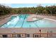 Expansive community pool area with zero entry and lap lanes, surrounded by lounge chairs and lush greenery at 1658 Pierce St, Charleston, SC 29492
