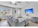 Bright living room featuring a comfy gray sofa, TV with beach scene, and a beach-themed color palette at 1658 Pierce St, Charleston, SC 29492