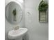 Charming powder room featuring a pedestal sink, round mirror, and decorative wreath, creating a welcoming space at 1722 Winfield Way, Charleston, SC 29414