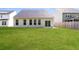 A spacious backyard featuring a grassy lawn, a patio, and a view of the home's exterior with large windows at 1730 Refuge Dr, Ladson, SC 29456