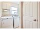 A laundry room with a Maytag washer and dryer, cabinets, a window, and a white door at 1834 Cornish Ave, Charleston, SC 29412