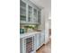Stylish bar area with pale blue cabinetry, mirrored backsplash, wine cooler, and brass hardware at 19 Ponce De Leon Ave, Charleston, SC 29407