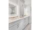 Well-lit bathroom featuring white cabinetry, marble countertops, and illuminated mirrors at 19 Ponce De Leon Ave, Charleston, SC 29407