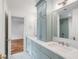 Bright bathroom with powder blue cabinets, marble countertops, double sinks, and a walk-in shower at 19 Ponce De Leon Ave, Charleston, SC 29407