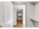 Walk-in closet featuring built-in shelving, brass rods, and hardwood floors at 19 Ponce De Leon Ave, Charleston, SC 29407