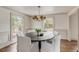 Elegant dining room with a dark wood round table, white chairs, and bright natural light at 19 Ponce De Leon Ave, Charleston, SC 29407