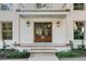 Close-up of the double front doors flanked by sconces and a neatly landscaped entrance at 19 Ponce De Leon Ave, Charleston, SC 29407