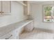 Bright laundry room features shaker cabinets, a marble countertop, and a view to the outdoors at 19 Ponce De Leon Ave, Charleston, SC 29407
