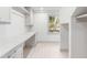 Well-lit laundry room features white cabinets, a countertop, and a window overlooking the outdoors at 19 Ponce De Leon Ave, Charleston, SC 29407