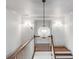 Elegant staircase features a decorative light fixture, white walls and hardwood stairs at 19 Ponce De Leon Ave, Charleston, SC 29407